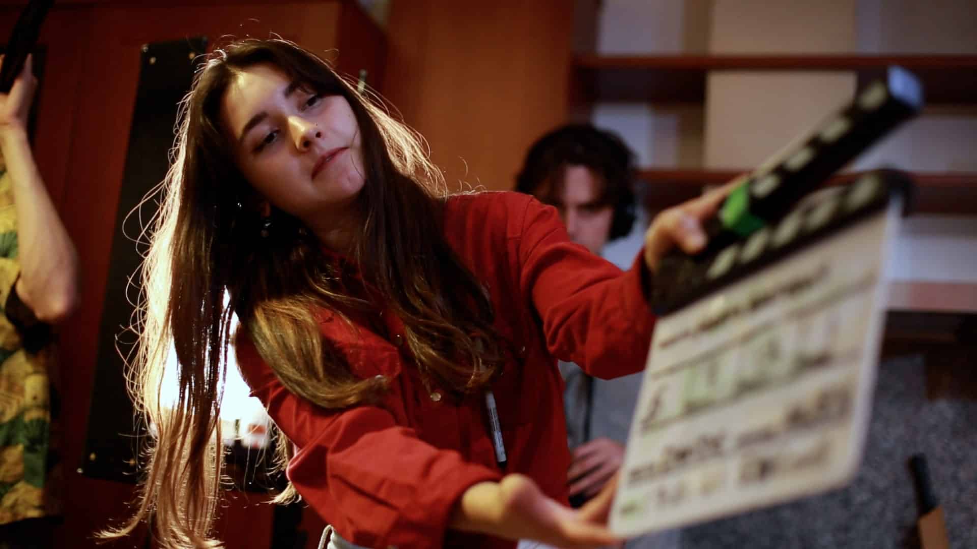 Student holding a film slate on set